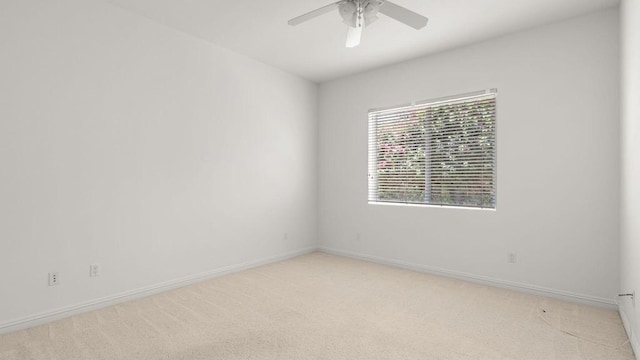 carpeted spare room with ceiling fan