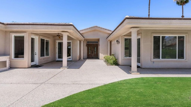 back of house with ceiling fan and a patio