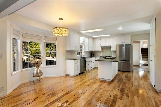 kitchen with white cabinetry, hanging light fixtures, light wood-type flooring, and appliances with stainless steel finishes