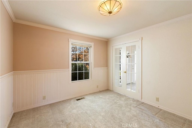 carpeted spare room featuring ornamental molding and french doors