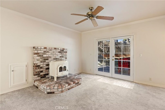 living room featuring a wood stove, ceiling fan, french doors, carpet, and ornamental molding