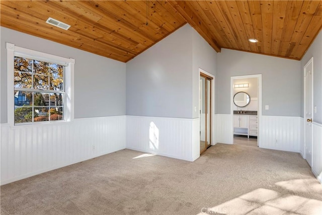 carpeted spare room featuring wooden ceiling, lofted ceiling, and sink