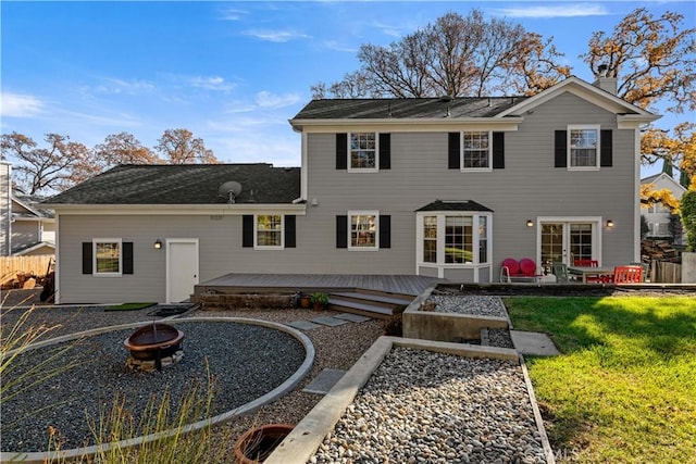 back of property with a lawn, an outdoor fire pit, and a wooden deck