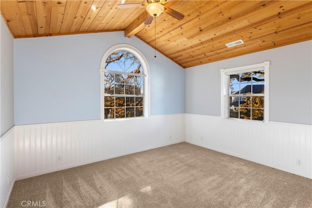 unfurnished room with vaulted ceiling with beams, ceiling fan, carpet, and wood ceiling