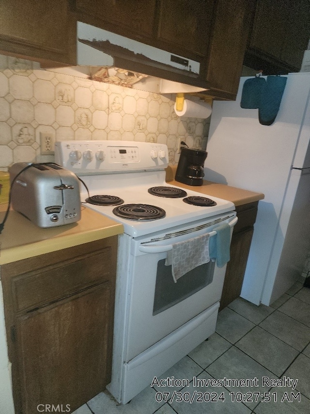 kitchen with dark brown cabinetry, backsplash, white range with electric stovetop, and light tile patterned flooring