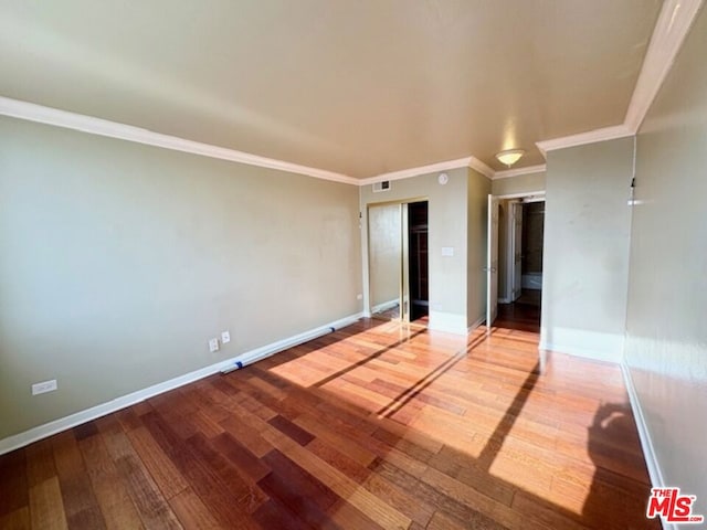 unfurnished room with wood-type flooring and ornamental molding