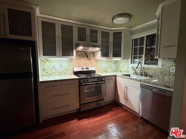 kitchen featuring light stone countertops, white cabinetry, stainless steel appliances, tasteful backsplash, and sink