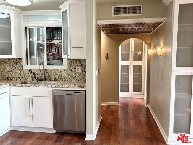 kitchen featuring backsplash, dishwasher, sink, and white cabinetry