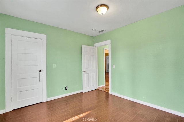 unfurnished room with dark wood-type flooring