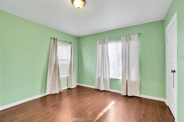 unfurnished room with dark wood-type flooring