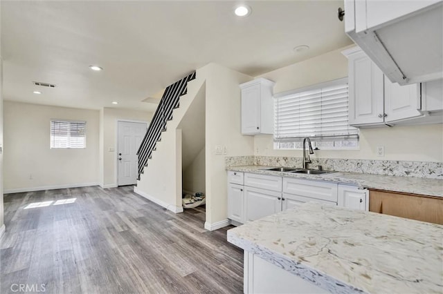 kitchen with white cabinets, light hardwood / wood-style floors, and sink