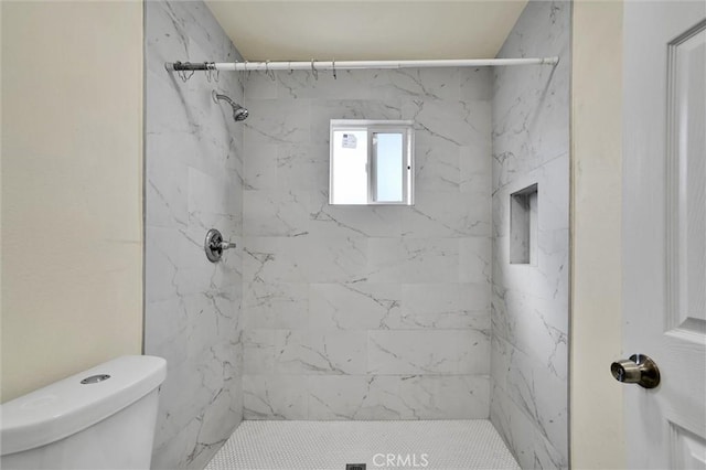 bathroom with toilet and tiled shower