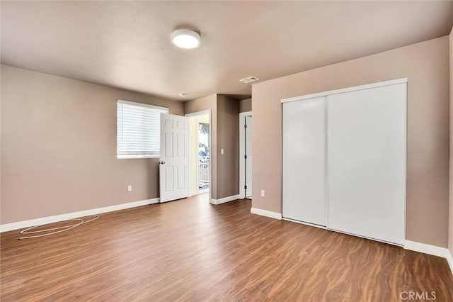 unfurnished bedroom with hardwood / wood-style flooring and a closet