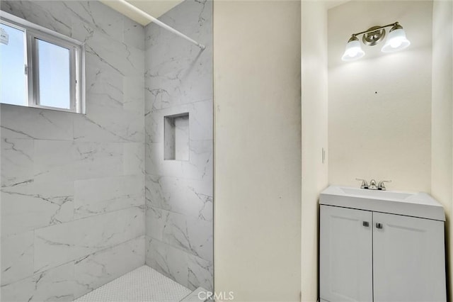 bathroom with vanity and tiled shower