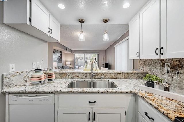 kitchen featuring dishwasher, white cabinets, sink, decorative backsplash, and decorative light fixtures