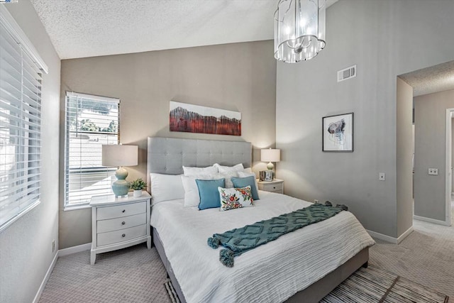 carpeted bedroom featuring a textured ceiling, an inviting chandelier, and vaulted ceiling