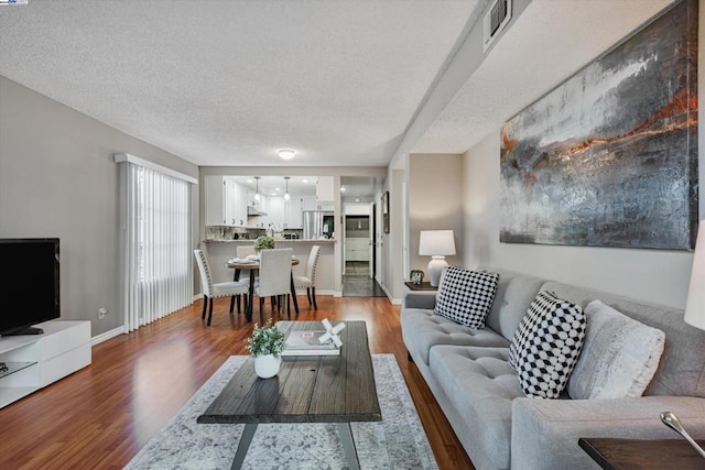 living room with hardwood / wood-style flooring and a textured ceiling