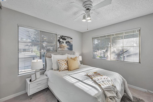 carpeted bedroom featuring a textured ceiling and ceiling fan