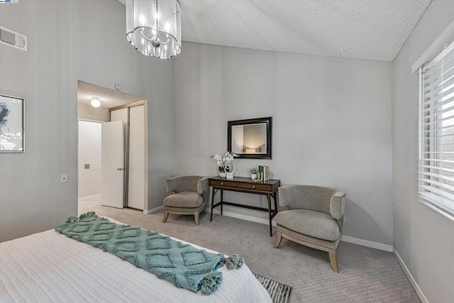 carpeted bedroom with a textured ceiling and an inviting chandelier