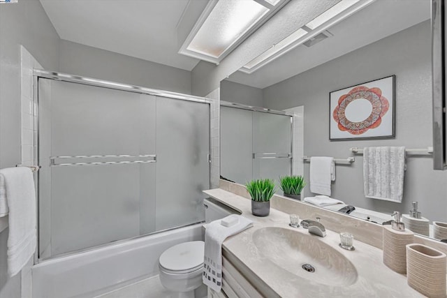 full bathroom featuring shower / bath combination with glass door, vanity, and toilet