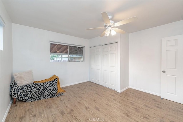 sitting room with ceiling fan and light wood-type flooring