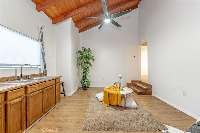 living room with beamed ceiling, light wood-type flooring, wood ceiling, and sink