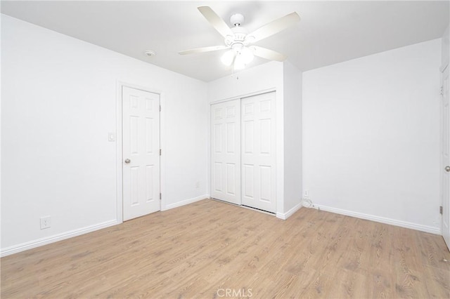 unfurnished bedroom featuring ceiling fan, a closet, and light hardwood / wood-style flooring