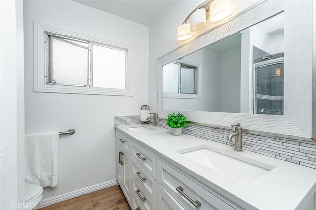 bathroom featuring tasteful backsplash, an enclosed shower, vanity, hardwood / wood-style flooring, and toilet