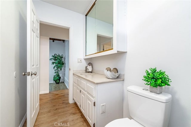 bathroom with hardwood / wood-style flooring, vanity, and toilet