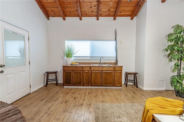 bar featuring beam ceiling, light hardwood / wood-style flooring, wooden ceiling, and sink