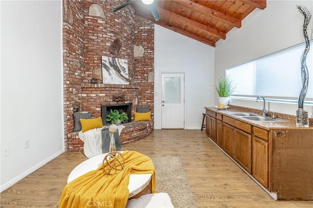 kitchen featuring beamed ceiling, light wood-type flooring, sink, and wood ceiling