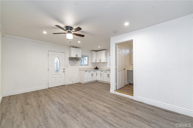 kitchen featuring ceiling fan, light hardwood / wood-style floors, white cabinetry, and crown molding