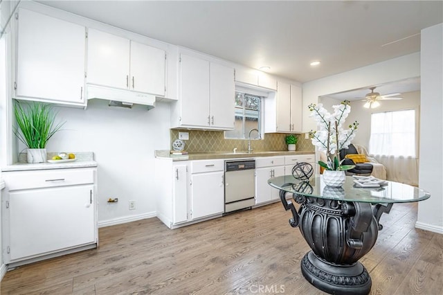 kitchen featuring decorative backsplash, light wood-type flooring, white cabinets, ceiling fan, and dishwasher