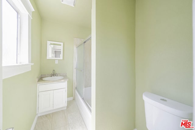 full bathroom featuring vanity, toilet, and enclosed tub / shower combo