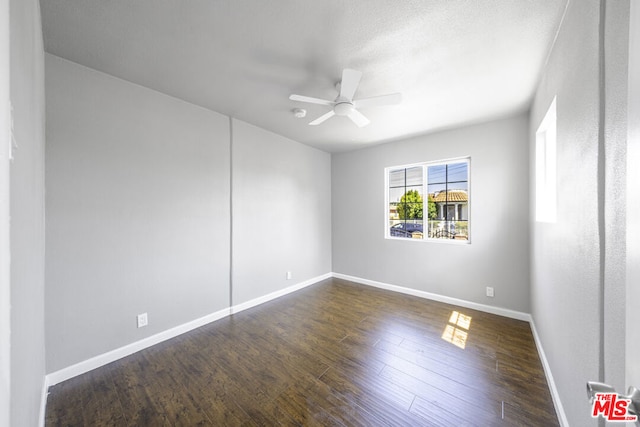 spare room featuring ceiling fan and dark hardwood / wood-style flooring