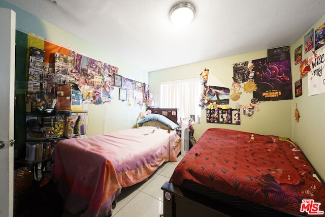 bedroom with light tile patterned flooring and a textured ceiling