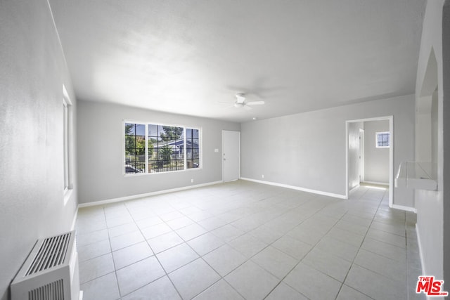 tiled spare room with ceiling fan