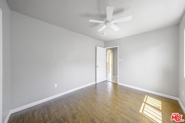 spare room with ceiling fan and dark hardwood / wood-style flooring