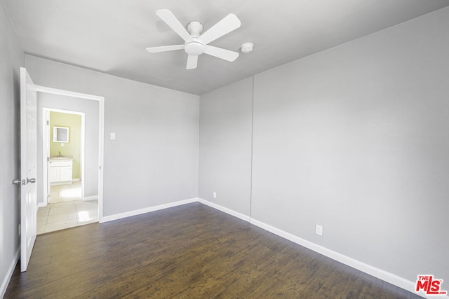 unfurnished room featuring ceiling fan and dark wood-type flooring