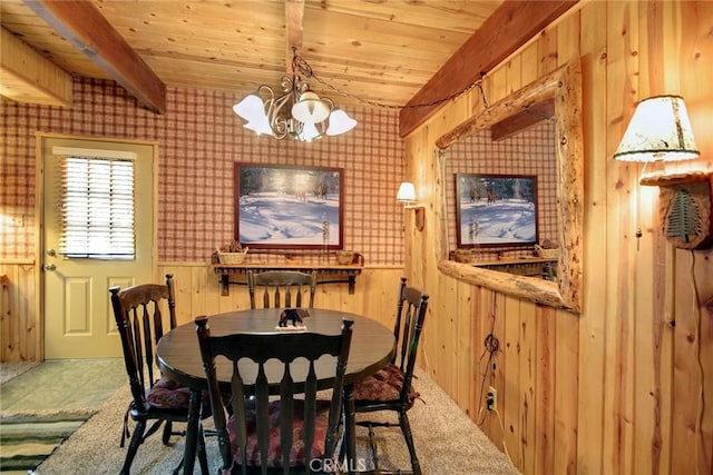 dining space with beamed ceiling, wooden walls, a notable chandelier, and wood ceiling