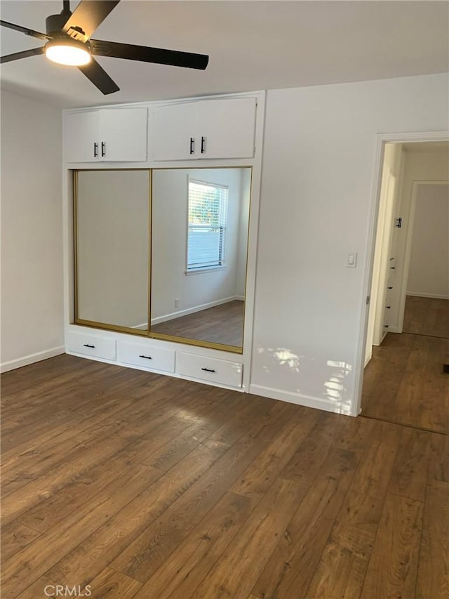 unfurnished bedroom featuring dark hardwood / wood-style flooring, a closet, and ceiling fan