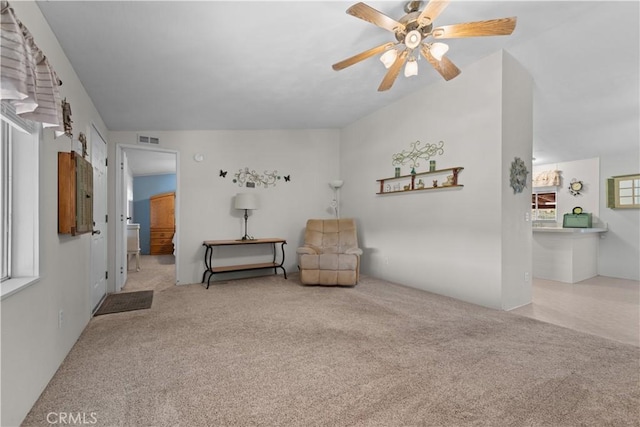 living area featuring lofted ceiling, light carpet, and ceiling fan