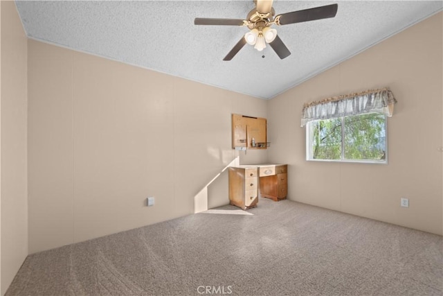 spare room with vaulted ceiling, a textured ceiling, ceiling fan, and carpet flooring