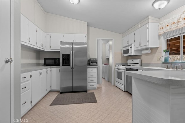 kitchen featuring white appliances, white cabinets, lofted ceiling, and sink