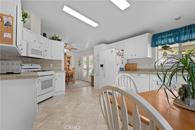 kitchen with white appliances, french doors, backsplash, white cabinetry, and ceiling fan