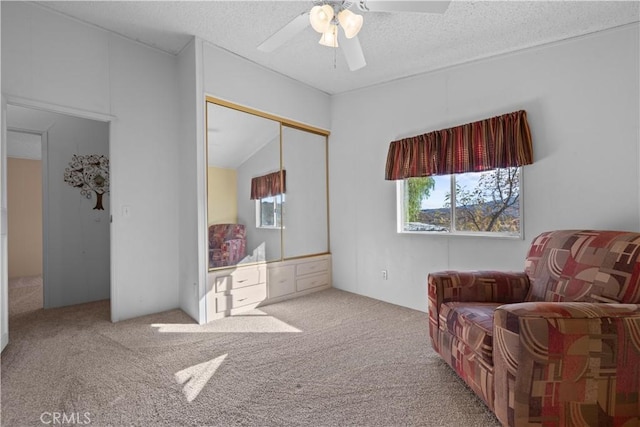 sitting room featuring ceiling fan, lofted ceiling, a textured ceiling, and carpet flooring