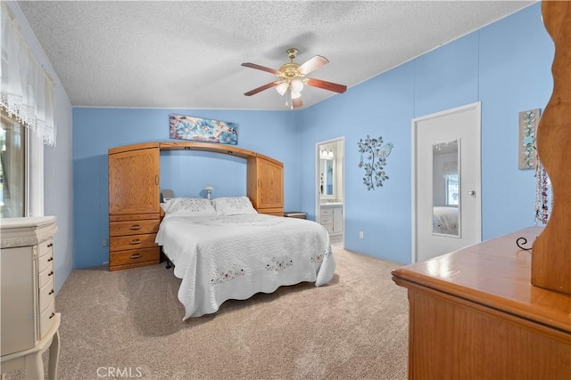 carpeted bedroom featuring ceiling fan, connected bathroom, and a textured ceiling