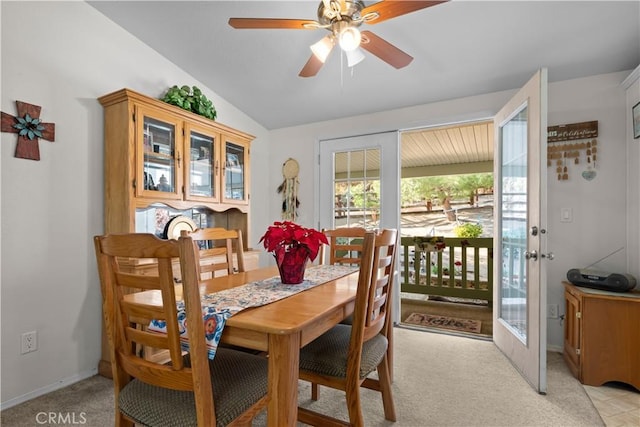 dining area with ceiling fan, light colored carpet, french doors, and lofted ceiling