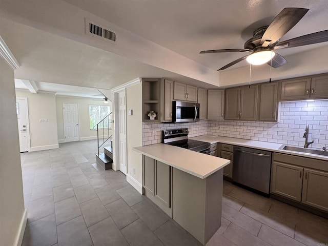 kitchen with sink, kitchen peninsula, decorative backsplash, light tile patterned flooring, and appliances with stainless steel finishes