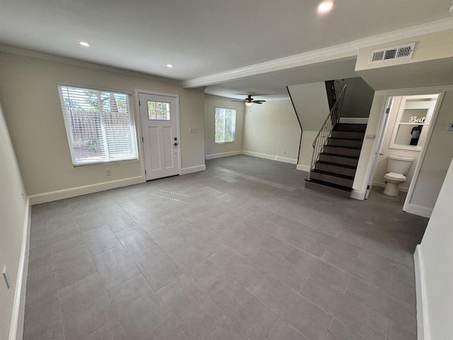 foyer with ceiling fan and crown molding